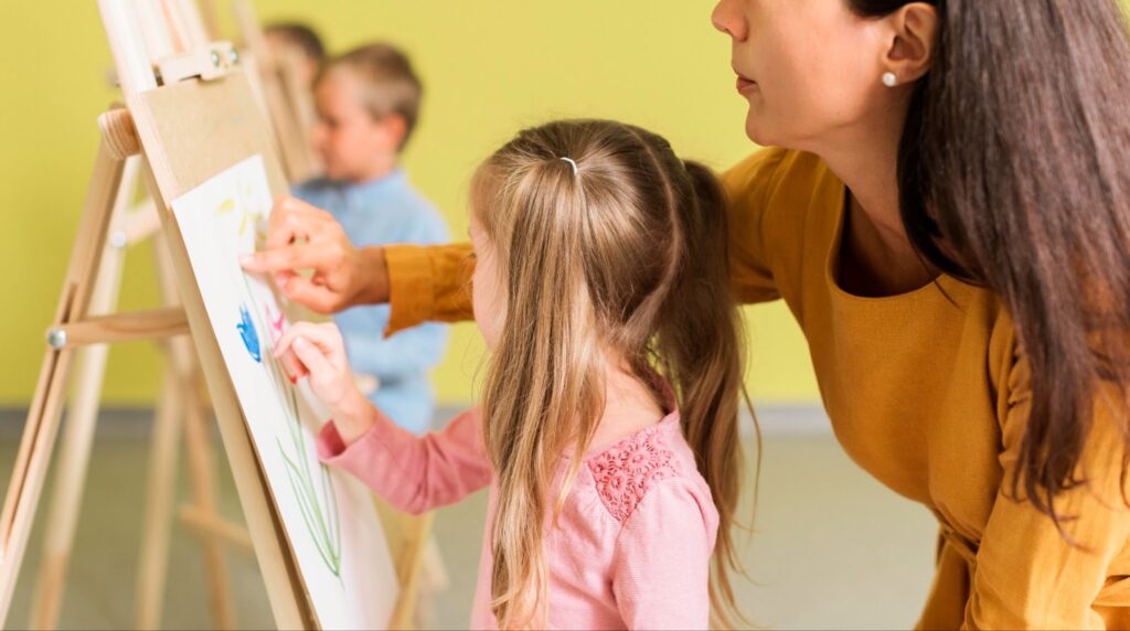 Teacher helping girl in drawing class